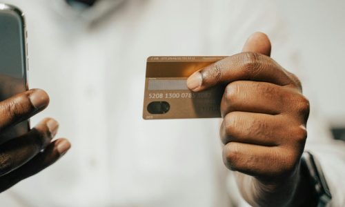 Person using a smartphone and credit card for online shopping or payment.