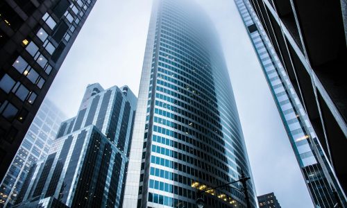 Dramatic view of modern skyscrapers shrouded in fog in an urban cityscape.